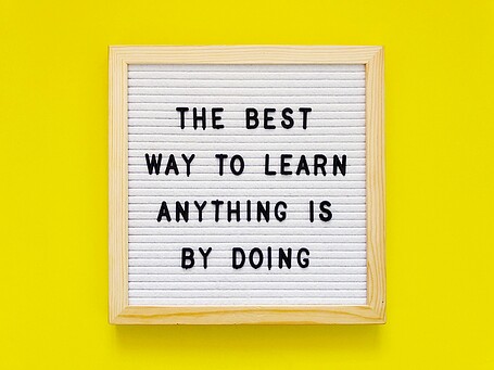 Bild mit Text auf gelbem Hintergrund: the best way to learn anything is by doing